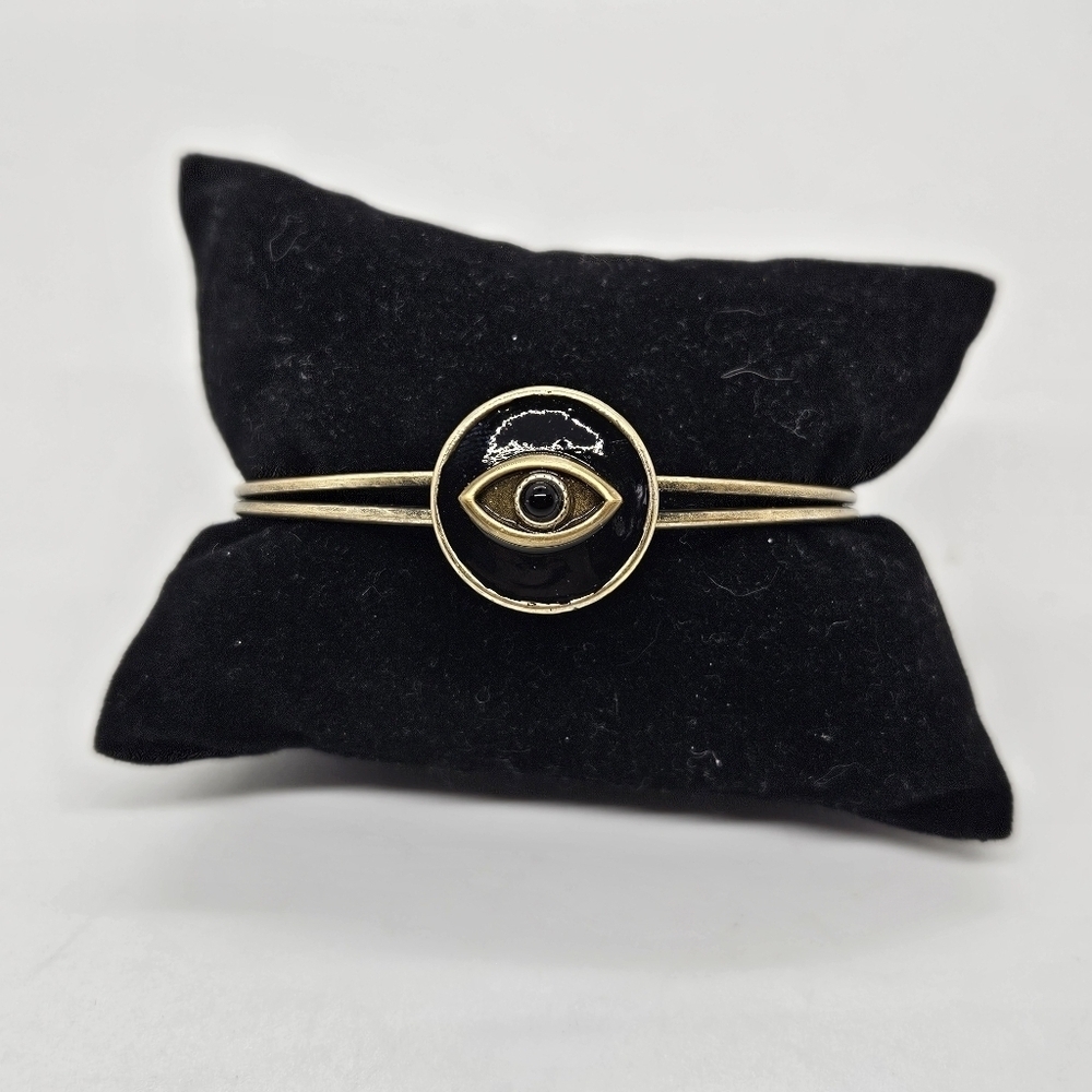gold tone cuff bracelet with black enamel eye